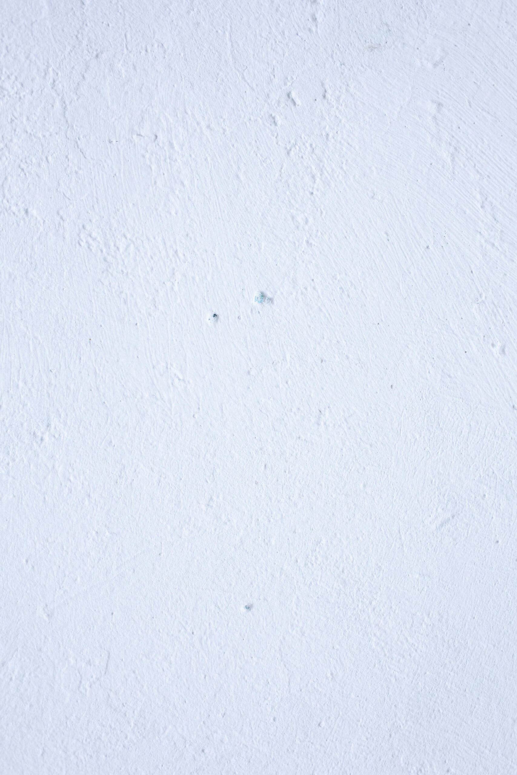 Image of a textured white wall with subtle imperfections, ideal for backgrounds.